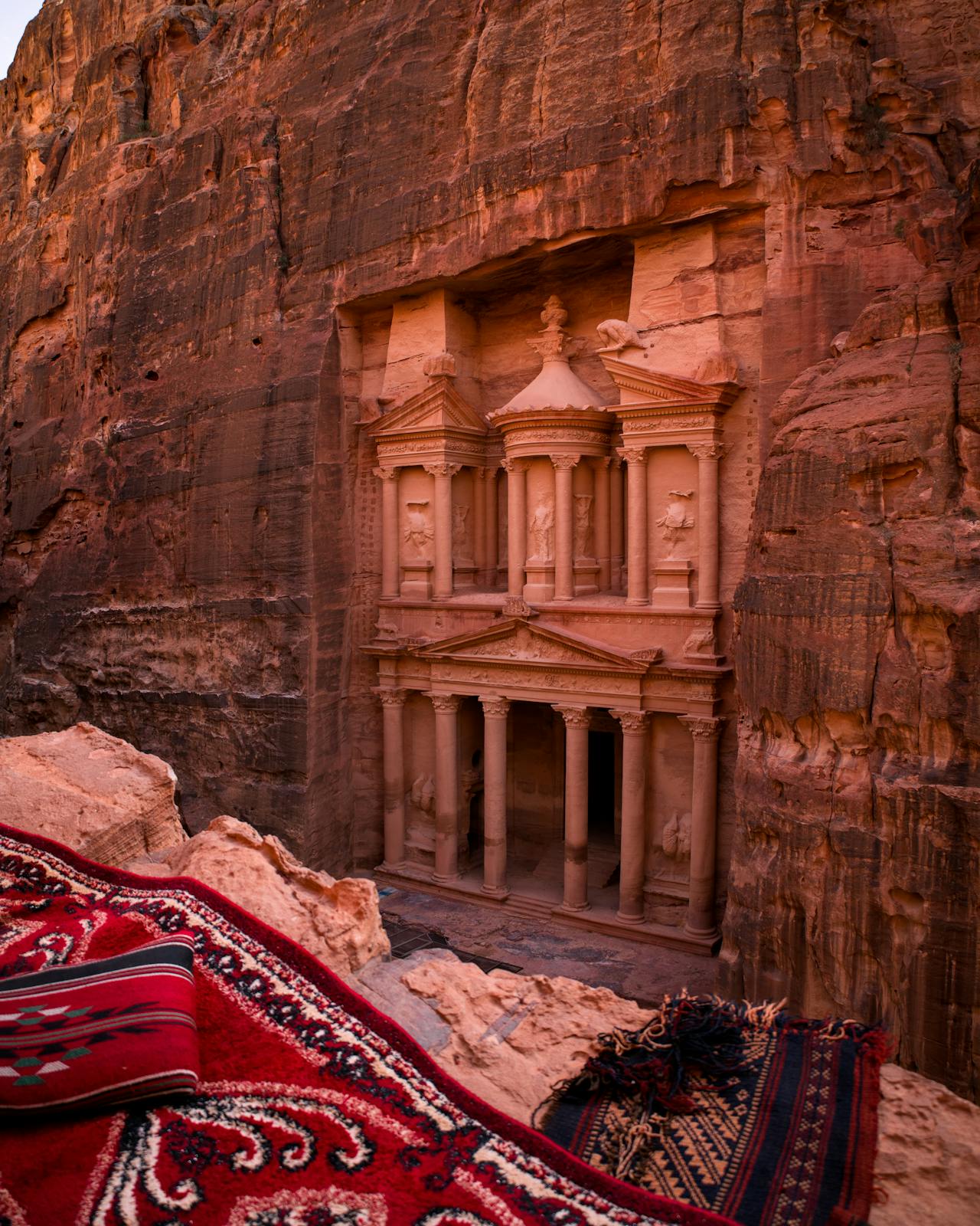 Explore the breathtaking Petra, Jordan, on a guided day tour from Amman. Witness the iconic Al-Khazneh (The Treasury) carved into stunning red sandstone cliffs, with tourists discovering this UNESCO World Heritage Site. Surrounded by rugged mountains and a mesmerizing desert landscape, this must-visit destination offers an unforgettable travel experience. Perfect for adventure seekers and history enthusiasts alike
