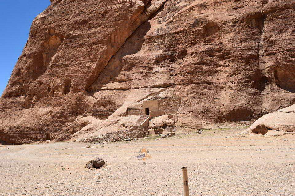 Nabataean rock-cut facade carved into rose-red cliffs at Little Petra